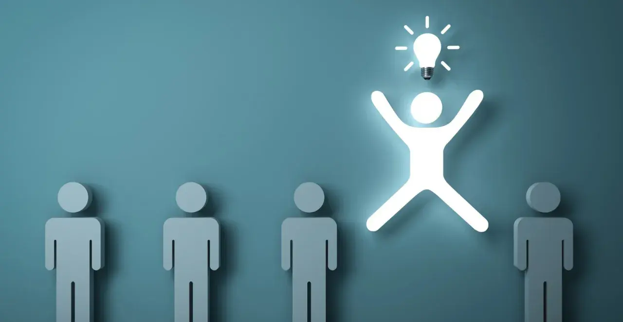 Una figura umana luminosa con una lampadina sopra la testa, simbolo di problem solving, si distingue da altre figure grigie.