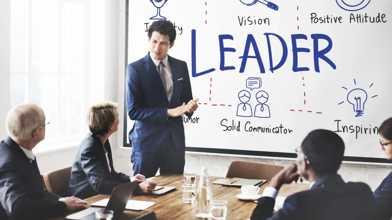 Uomo d'affari presenta i modelli di leadership: visione, positività, comunicazione e ispirazione.