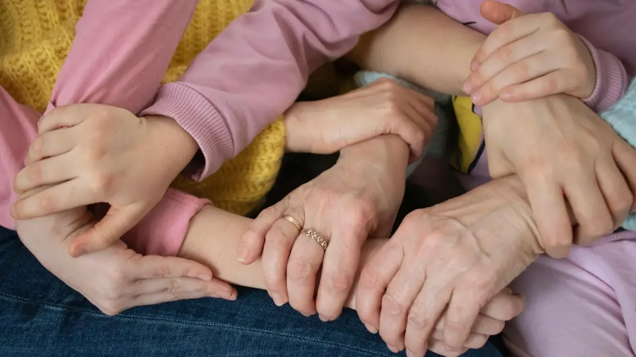 Mani intrecciate, un abbraccio di supporto. Un esempio di empatia nel lavoro, dove la collaborazione crea un legame forte e sicuro.
