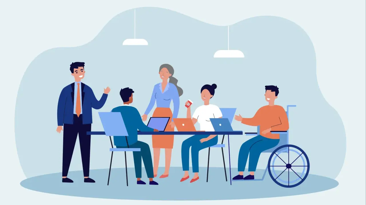 Team di lavoro eterogeneo, con persone di diverse età e un uomo in carrozzina, che collaborano in un ufficio moderno. Esempio di diversity management.