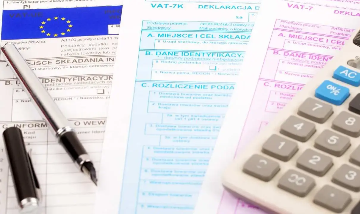 Documenti fiscali per il commercio auto usate regime forfettario. Penna e calcolatrice su moduli IVA.