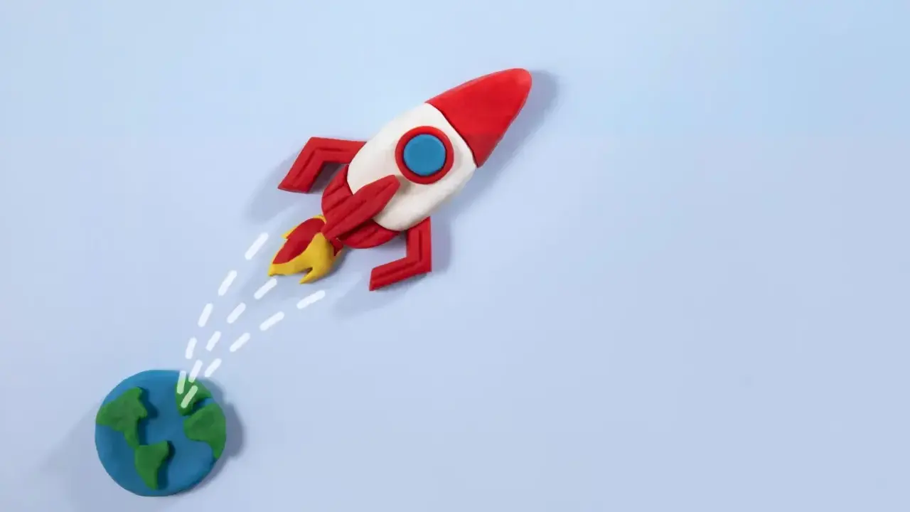 Un razzo di plastilina decolla dalla Terra, pronto per nuove avventure. La risposta a "perché vuoi lavorare con noi" è: per spiccare il volo verso il successo!