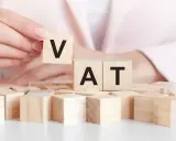 Dita che compongono la parola VAT con blocchi di legno. Un intestatario partita IVA che gioca con le lettere.