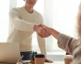 Due persone si stringono la mano, un gesto che può simboleggiare la conclusione di un rapporto lavorativo, il vero offboarding significato.