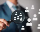Un hiring manager esamina attentamente i candidati con una lente d'ingrandimento, cercando il talento giusto.