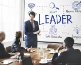 Uomo d'affari presenta i modelli di leadership: visione, positività, comunicazione e ispirazione.