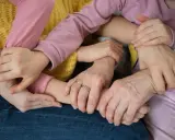 Mani intrecciate, un abbraccio di supporto. Un esempio di empatia nel lavoro, dove la collaborazione crea un legame forte e sicuro.