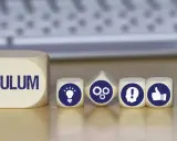 Dadi con icone che rappresentano idee, ingranaggi, persona e pollice in su, accanto a un blocco con la scritta "CURRICULUM". Simboleggiano le competenze informatiche e lo sviluppo professionale.