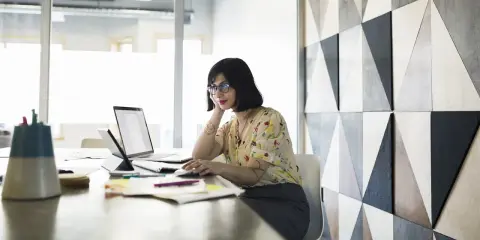 Donna al computer, concentrata, mentre prepara una candidatura spontanea.