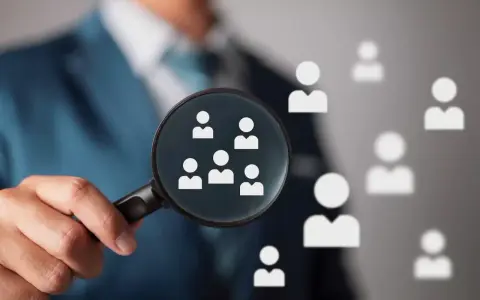 Un hiring manager esamina attentamente i candidati con una lente d'ingrandimento, cercando il talento giusto.