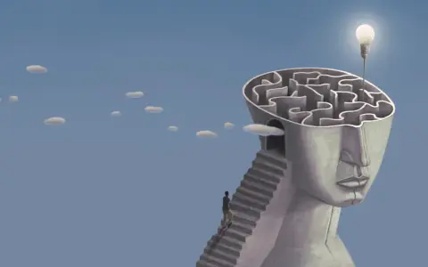 Un uomo sale una scala verso un labirinto nella testa di una statua, simbolo di esempi di problem solving nella vita quotidiana. Una lampadina illumina la soluzione.