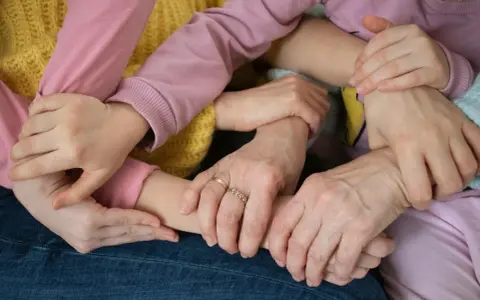 Mani intrecciate, un abbraccio di supporto. Un esempio di empatia nel lavoro, dove la collaborazione crea un legame forte e sicuro.