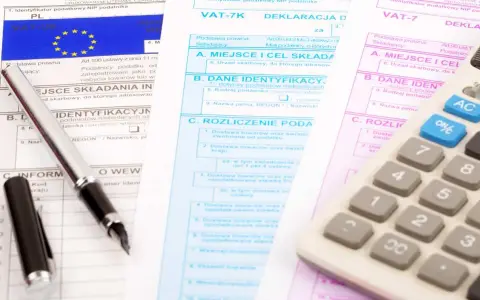 Documenti fiscali per il commercio auto usate regime forfettario. Penna e calcolatrice su moduli IVA.