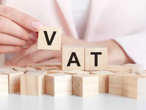 Dita che compongono la parola VAT con blocchi di legno. Un intestatario partita IVA che gioca con le lettere.