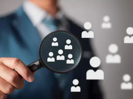 Un hiring manager esamina attentamente i candidati con una lente d'ingrandimento, cercando il talento giusto.