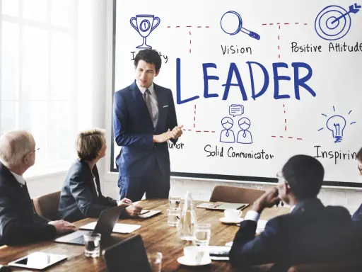 Uomo d'affari presenta i modelli di leadership: visione, positività, comunicazione e ispirazione.