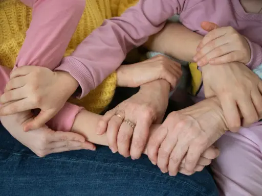 Mani intrecciate, un abbraccio di supporto. Un esempio di empatia nel lavoro, dove la collaborazione crea un legame forte e sicuro.