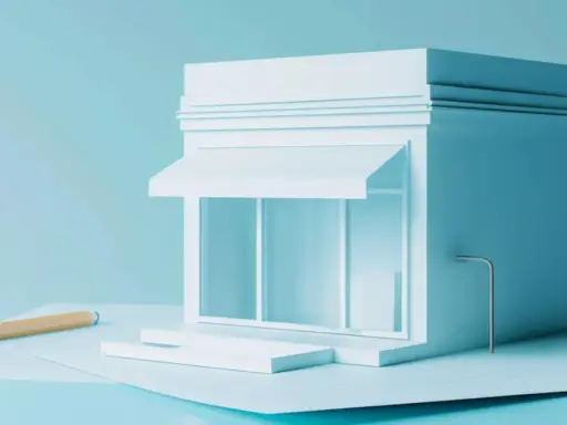 Un modello di negozio bianco su sfondo azzurro, con una matita e fogli. Quanti codici ATECO si possono avere per un'attività?