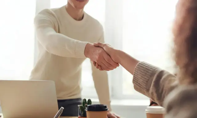 Due persone si stringono la mano, un gesto che può simboleggiare la conclusione di un rapporto lavorativo, il vero offboarding significato.