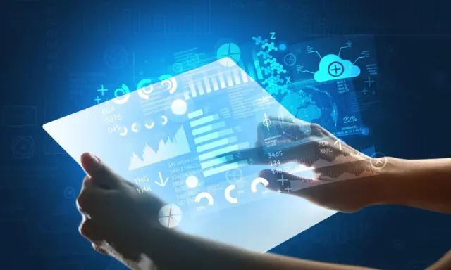 Hands holding a futuristic tablet displaying glowing data, charts, and a globe.
