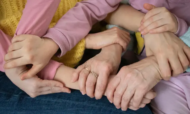 Mani intrecciate, un abbraccio di supporto. Un esempio di empatia nel lavoro, dove la collaborazione crea un legame forte e sicuro.