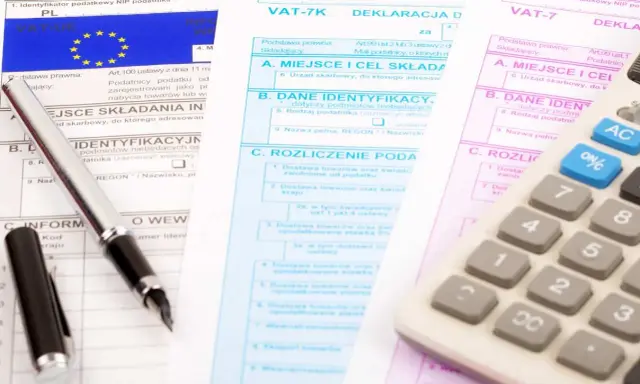 Documenti fiscali per il commercio auto usate regime forfettario. Penna e calcolatrice su moduli IVA.