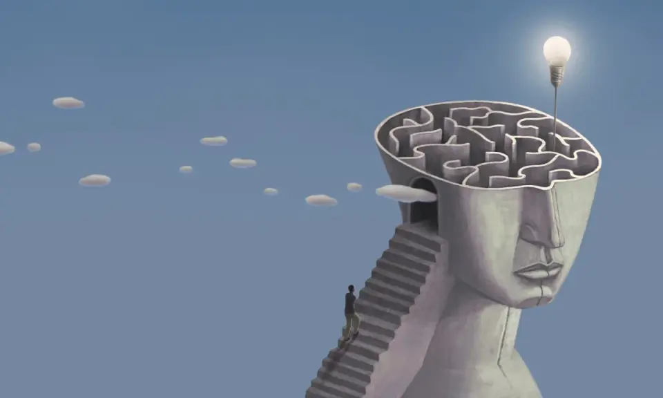 Un uomo sale una scala verso un labirinto nella testa di una statua, simbolo di esempi di problem solving nella vita quotidiana. Una lampadina illumina la soluzione.