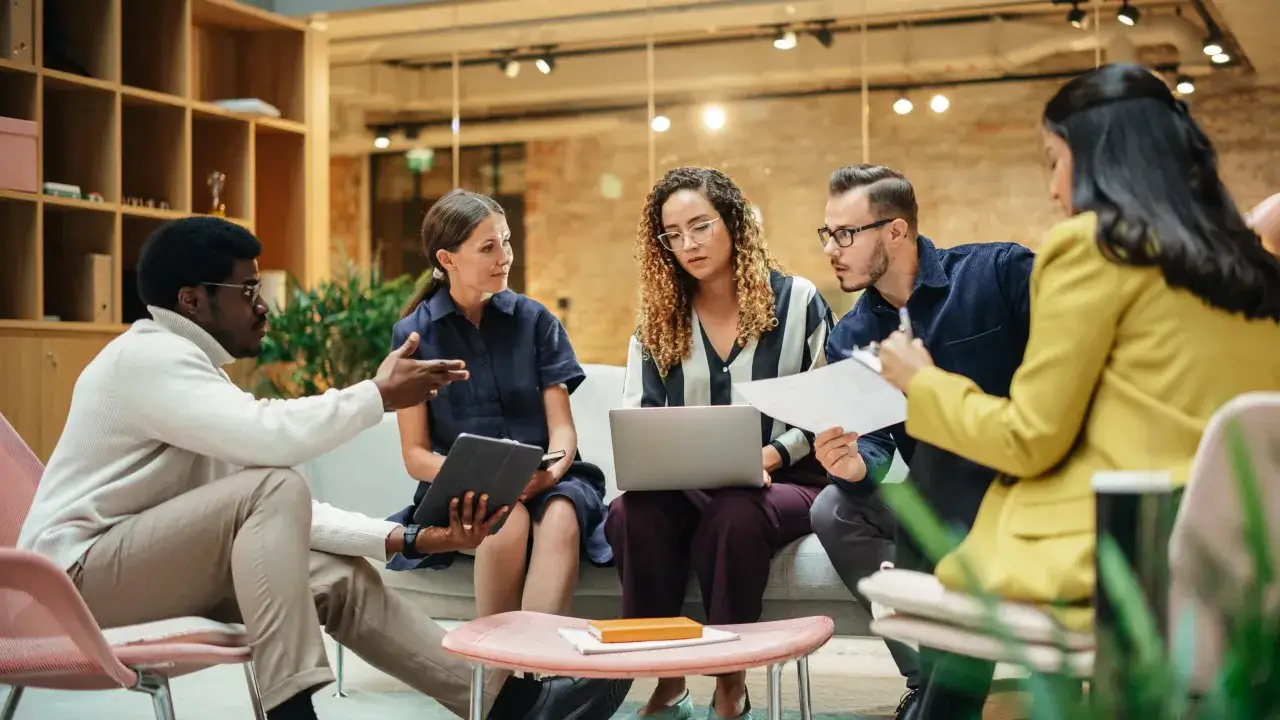 Team discute idee, mostrando esempi di comunicazione interna efficace.
