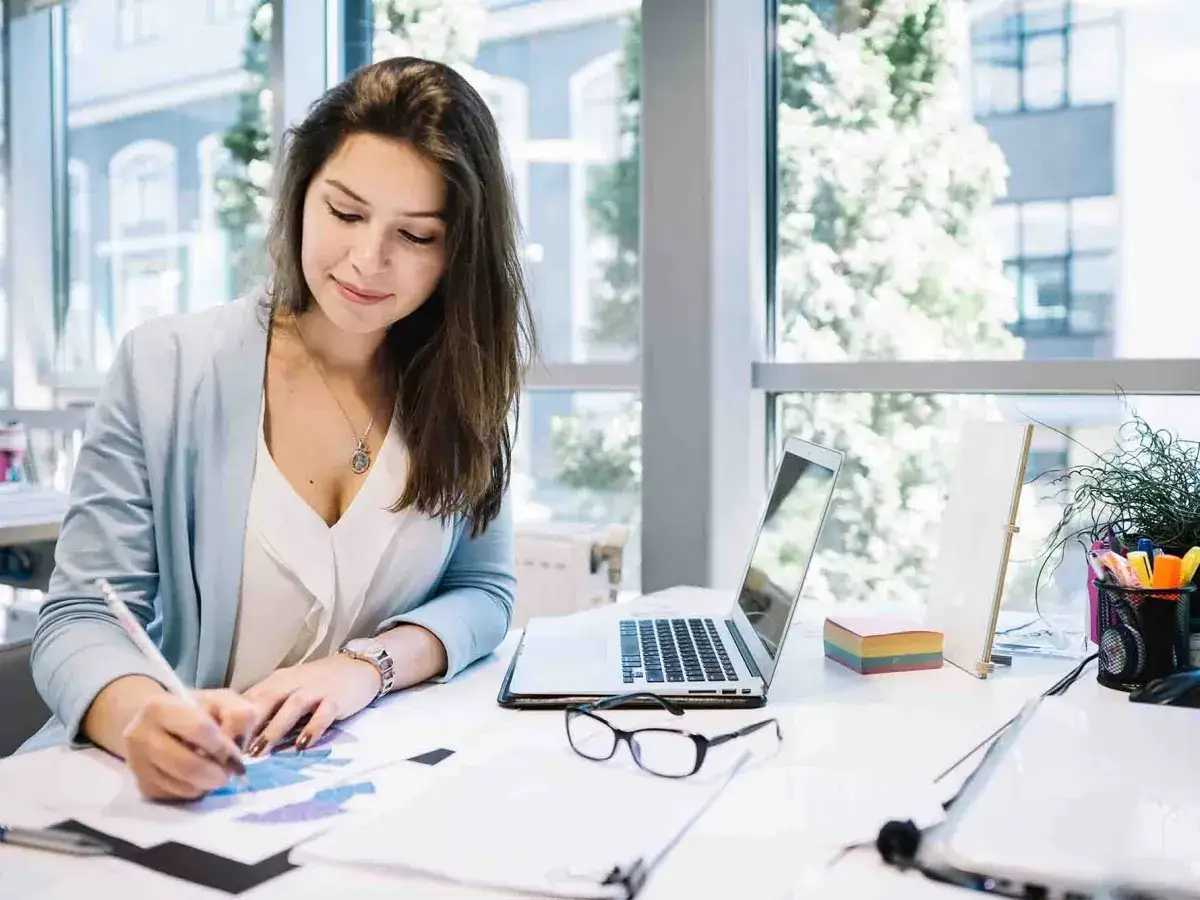 Donna al lavoro, concentrata su grafici. Forse sta valutando la sospensione partita iva per ottimizzare le spese.