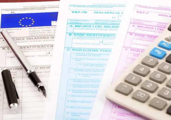 Documenti fiscali per il commercio auto usate regime forfettario. Penna e calcolatrice su moduli IVA.